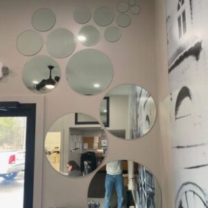 Many circular mirrors create a bubble effect on a wall